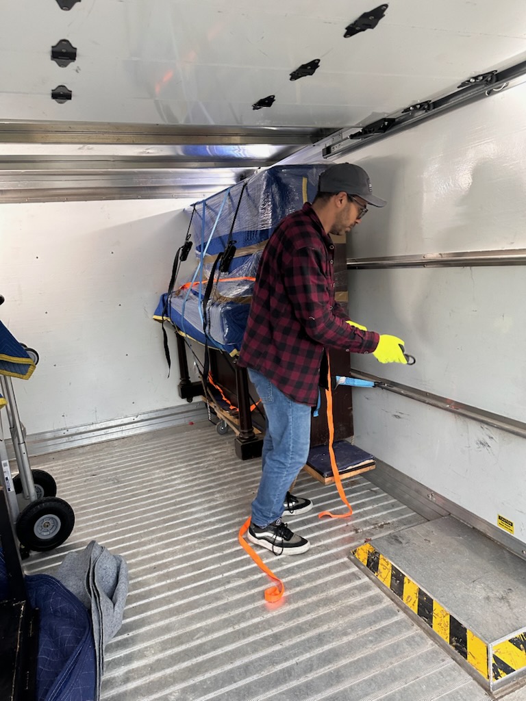 Our mover beside a wrapped upright piano in the truck
